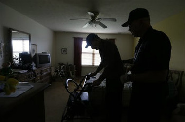 Caregiver Warren Manchess helping Paul Gregoline leave the bedroom, in Noblesville, Ind. (AP Photo/Darron Cummings)