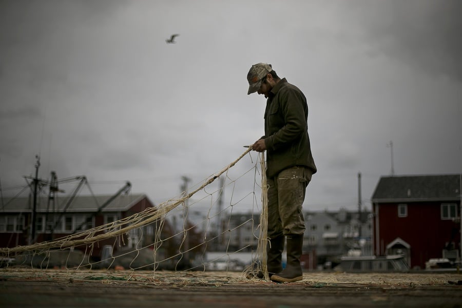 With stormy weather approaching, fisherman Brandon Wyman of Harpswell, Maine, repairs a trawling net, Wednesday, Oct. 28, 2015, in Portland, Maine. (AP Photo/Robert F. Bukaty)