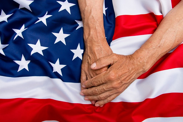 Hands of an elderly veteran on the flag of the United States of America. (Photo: Shutterstock)